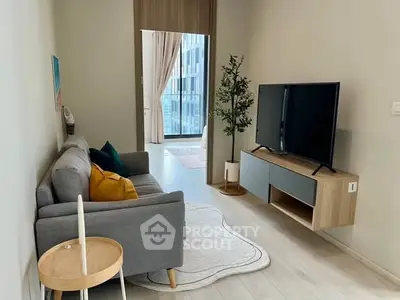 Modern living room with sleek TV setup and cozy sofa in stylish apartment.
