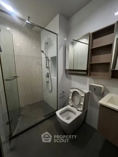 Modern bathroom with glass shower and sleek fixtures in a contemporary apartment.