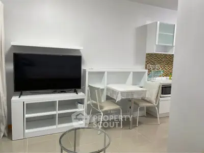 Modern compact living space with TV, dining area, and stylish kitchen
