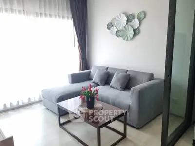 Modern living room with stylish gray sofa and decorative wall art, perfect for cozy relaxation.