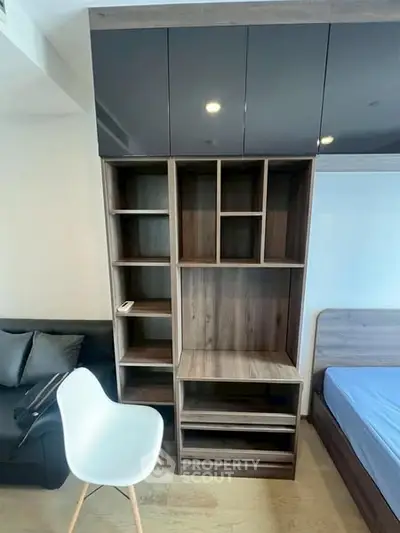 Modern bedroom with sleek storage unit and stylish chair