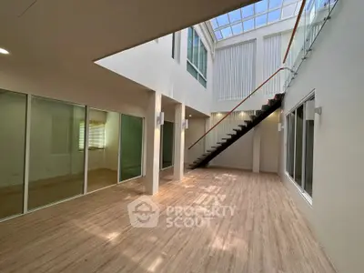 Spacious modern interior with skylight and elegant staircase, perfect for natural light lovers.