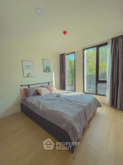 Bright and cozy bedroom with large windows and modern decor.