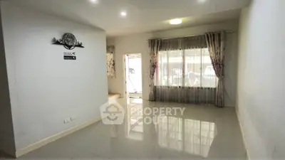 Spacious living room with large window and glossy tiled floor