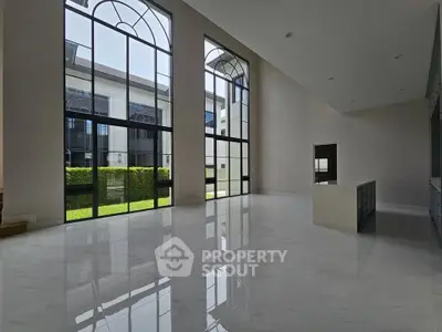 Luxurious modern living room with high ceilings and large windows offering abundant natural light.