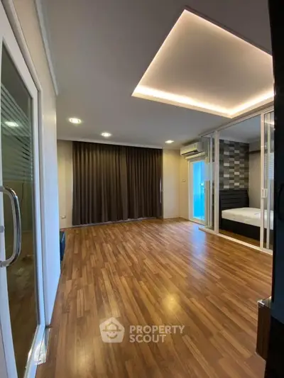 Spacious modern living room with wooden flooring and stylish ceiling lights