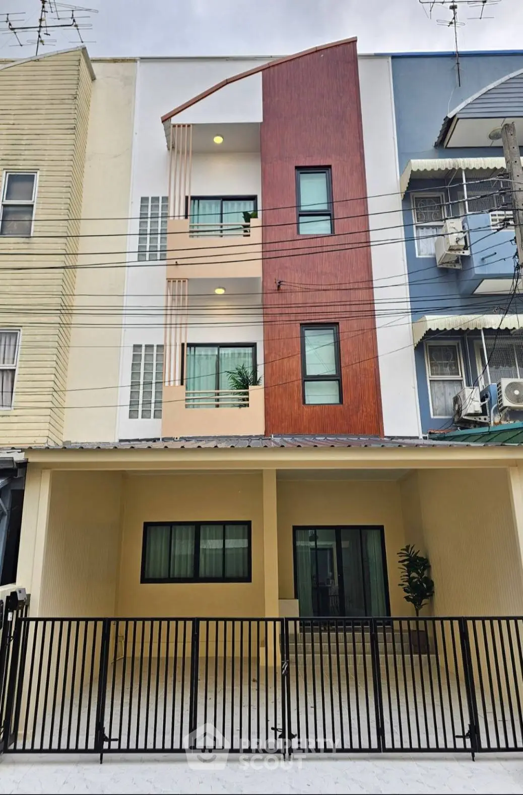 Modern townhouse exterior with unique facade design and gated entrance, perfect for urban living.