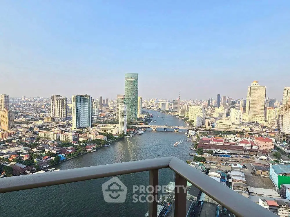 Stunning cityscape view from high-rise balcony overlooking river and skyline.