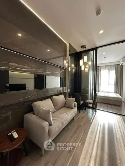 Modern living room with sleek design and natural light, featuring a cozy sofa and elegant decor.