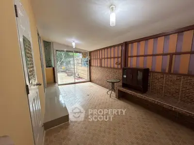 Spacious living room with unique brick wall and large window view