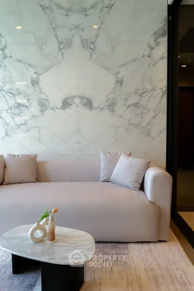 Elegant living room with marble accent wall and modern sofa