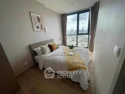Modern bedroom with city view, featuring cozy bed and stylish decor in high-rise apartment.