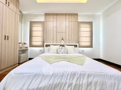 Elegant bedroom with modern design and cozy ambiance, featuring stylish wooden accents and ample natural light.