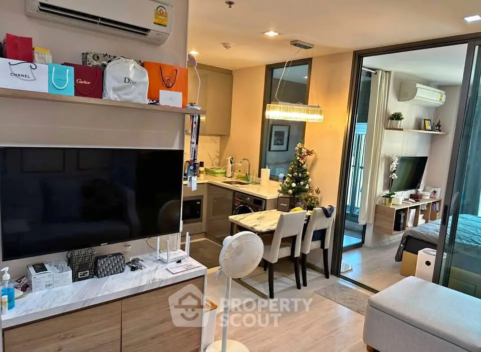 Modern open-plan living room with kitchen and dining area, featuring stylish decor and ample natural light.