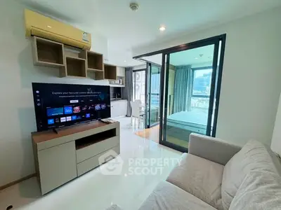 Modern living room with TV and sliding glass doors to bedroom in a stylish apartment.
