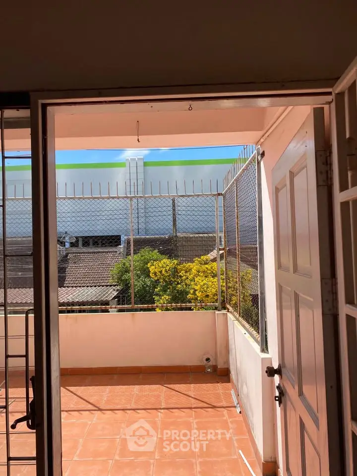 Charming balcony with terracotta tiles and garden view, perfect for relaxation and outdoor enjoyment.
