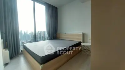 Modern bedroom with large window offering stunning city view, featuring minimalist decor and cozy ambiance.