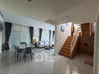 Spacious modern living room with elegant dining area and staircase