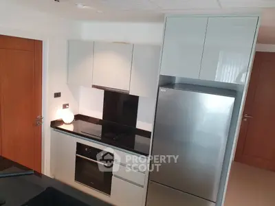 Modern kitchen with sleek cabinetry and stainless steel appliances in a contemporary apartment.