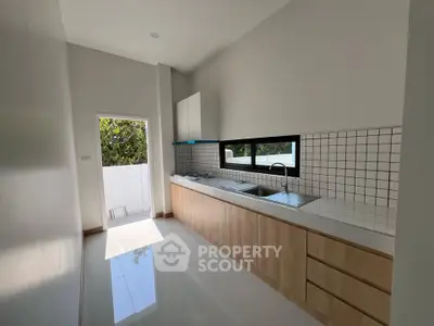 Modern kitchen with sleek cabinetry and large window for natural light