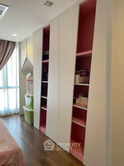 Modern bedroom with sleek built-in storage and elegant wooden flooring