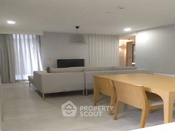 Modern living room with stylish furniture and dining area in open layout.