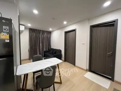 Modern apartment interior with dining area and cozy living space, featuring sleek furniture and ambient lighting.
