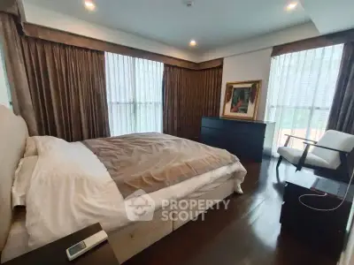 Luxurious bedroom with elegant decor and large windows in a modern apartment.