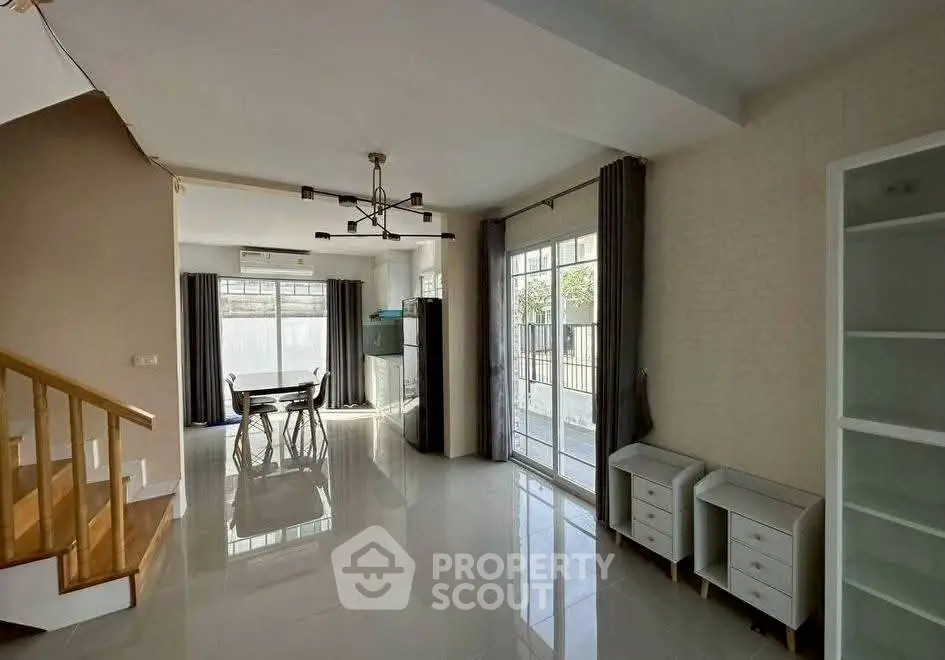 Spacious living room with modern chandelier and large windows for natural light