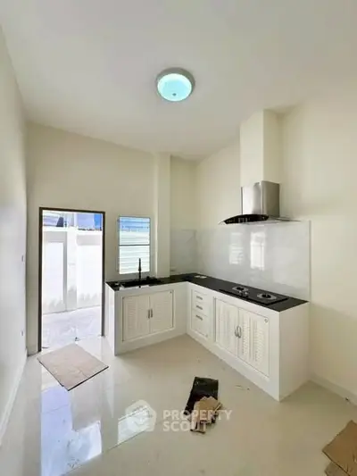 Modern kitchen with sleek countertops and gas stove in a bright, minimalist design.