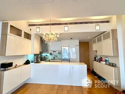 Luxurious modern kitchen with sleek white cabinetry and elegant chandelier lighting