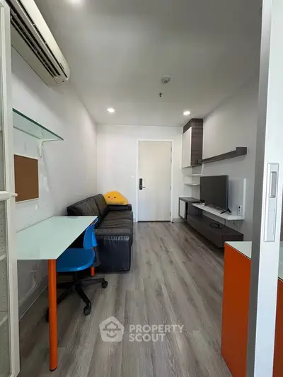 Modern living room with sleek furniture and wooden flooring, featuring a cozy sofa and a stylish desk.