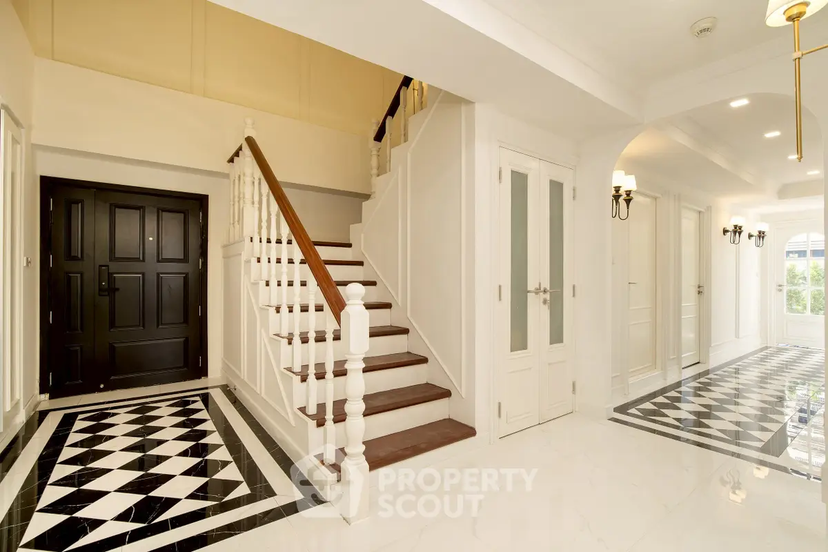 Elegant entrance with stylish staircase and checkered floor tiles