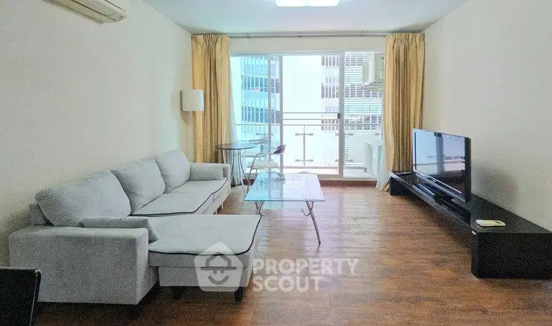 Spacious living room with modern furniture and large windows offering city views.