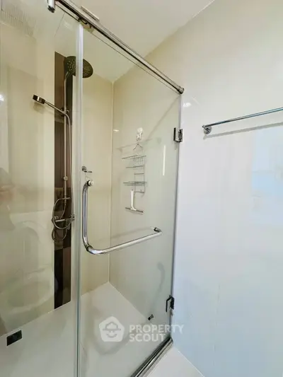 Modern bathroom with glass shower enclosure and sleek fixtures in a contemporary home.