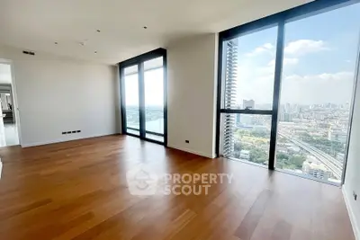 Spacious modern living room with stunning city view and floor-to-ceiling windows.