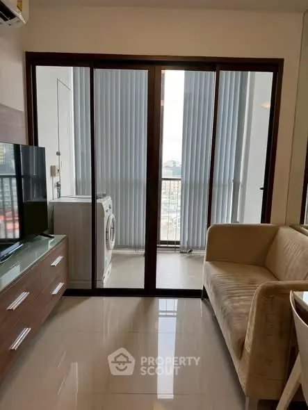 Modern living room with sliding glass doors and washing machine on balcony.