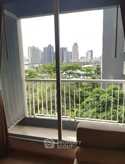 Spacious balcony with stunning cityscape view and lush greenery, perfect for relaxation and enjoying urban living.