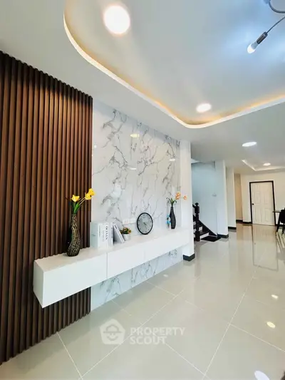Modern living room with elegant marble accent wall and sleek lighting