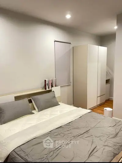 Modern bedroom with sleek design and neutral tones, featuring a comfortable bed and ample storage space.