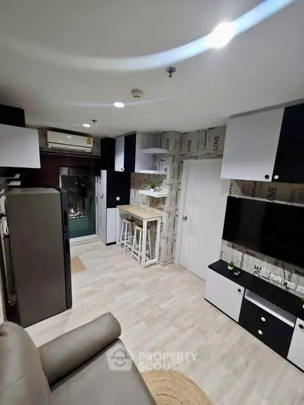 Modern living room with stylish decor and open kitchen layout in a cozy apartment.