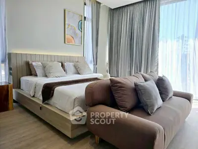 Luxurious bedroom with modern decor and large windows offering natural light.