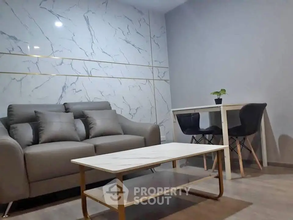 Modern living room with stylish marble accent wall and cozy seating area.