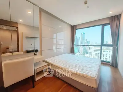 Modern bedroom with city view, featuring large windows and sleek furnishings.
