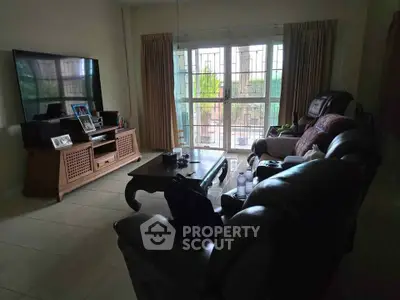 Cozy living room with large TV and comfortable seating, perfect for relaxation and entertainment.