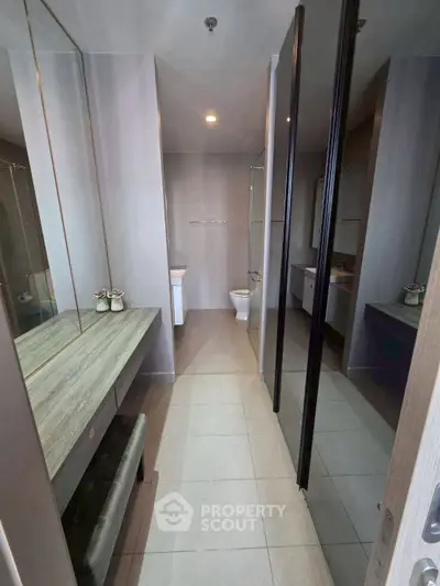Modern bathroom with sleek design and spacious layout, featuring a large mirror and elegant fixtures.