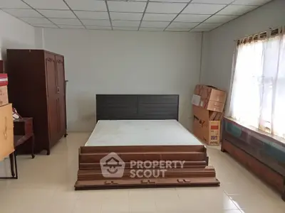 Spacious bedroom with large window and classic wooden furniture