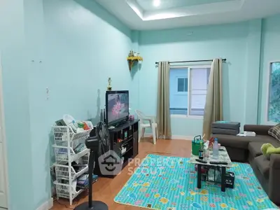 Cozy living room with teal walls, TV, and modern furniture