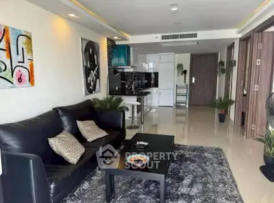 Modern living room with sleek black sofa and open kitchen layout