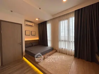 Modern bedroom with ambient lighting and large windows in a stylish apartment.